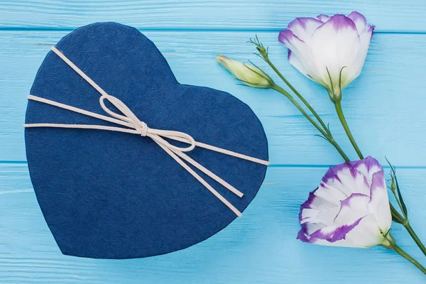 Blue heart shaped box and flowers.