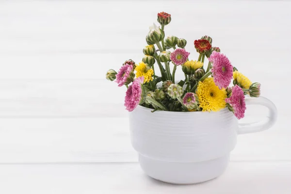 Unripe flowers in a white mug. — Stock Photo, Image