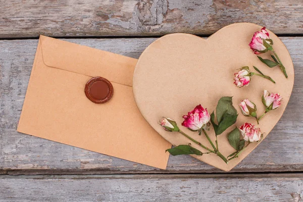 Sobres, cartón en forma de corazón y flores de rosas . — Foto de Stock