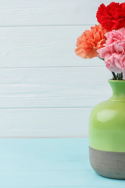 Jarrón de cerámica verde con flores de clavel . — Foto de Stock