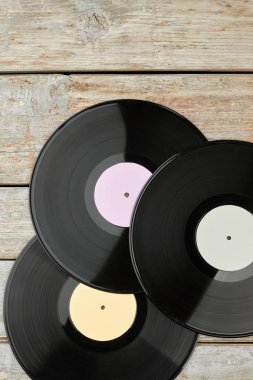 Vinil kayıtlar üzerinde ahşap arka plan, üstten görünüm.