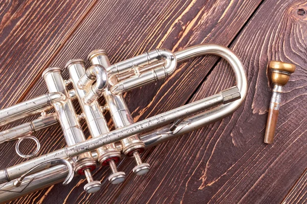 Silver trumpet på brun trä bakgrund. — Stockfoto