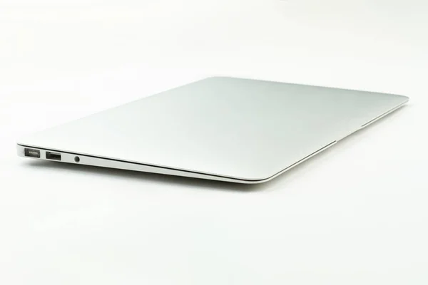 ZAMKNIĘTA laptopa na pulpicie biały. — Zdjęcie stockowe