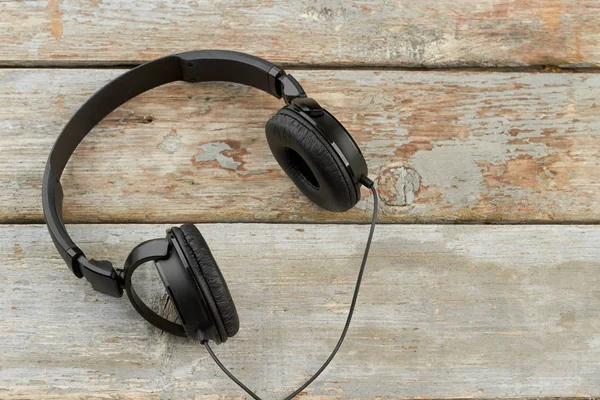 Auriculares negros en tablones de madera vintage . —  Fotos de Stock