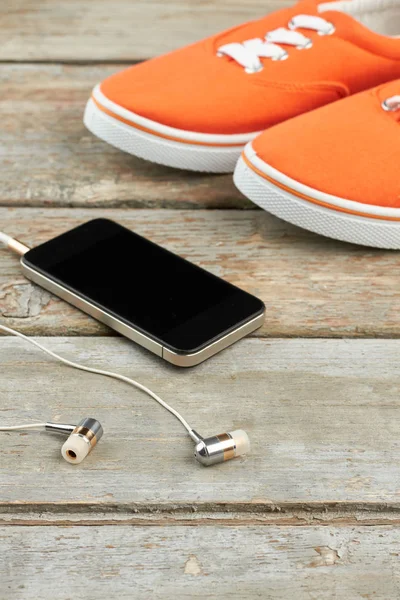 Scarpe sportive, auricolari e smartphone . — Foto Stock