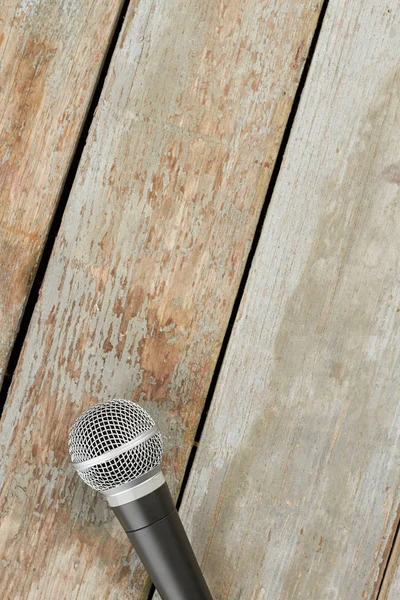 Microphone on wooden background and text space. Gray microphone on vintage wooden background with copy space on top.