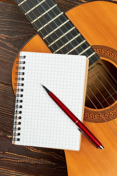 Guitarra con cuaderno en blanco y pluma . — Foto de Stock