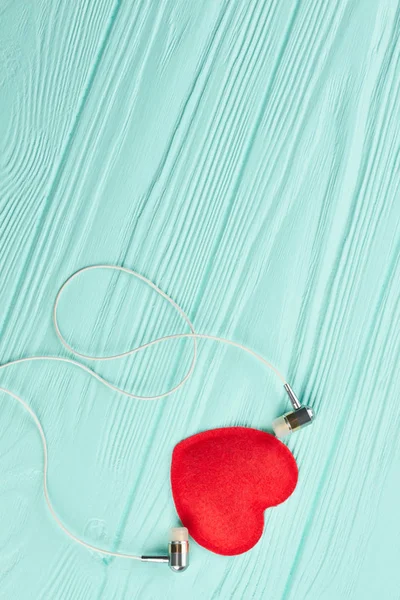 Écouteurs et coeur rouge sur fond en bois . — Photo