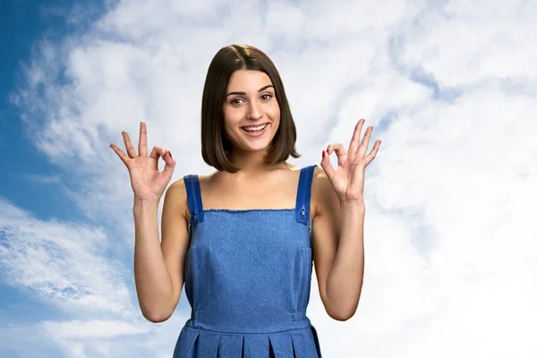 Ragazza gesticolando ok su sfondo cielo nuvoloso . — Foto Stock