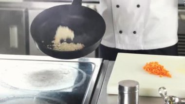 Şef mutfakta yemek pişiriyor..