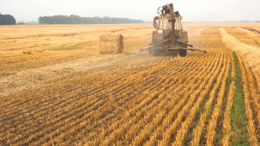 Sarı alanda sürme traktör.