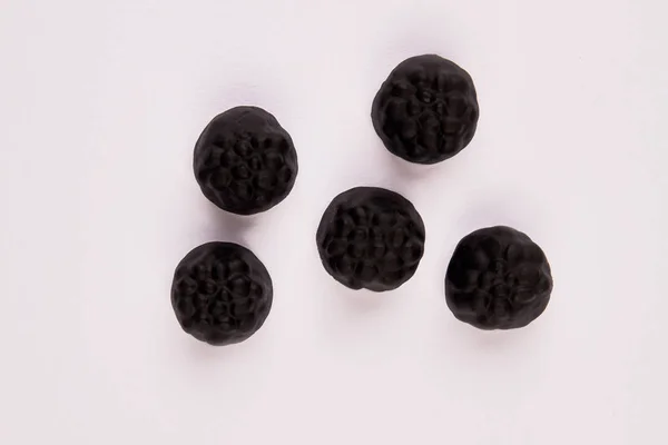 Caramelos negros sobre fondo blanco . — Foto de Stock