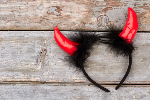 Devil hair band on wooden background.