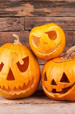 Ahşap arka planda Cadılar Bayramı balkabakları.