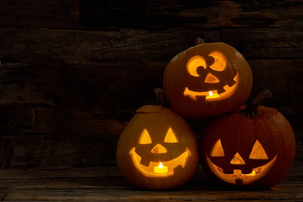 Three pumpkin Jack-O-Lantern with happy faces.