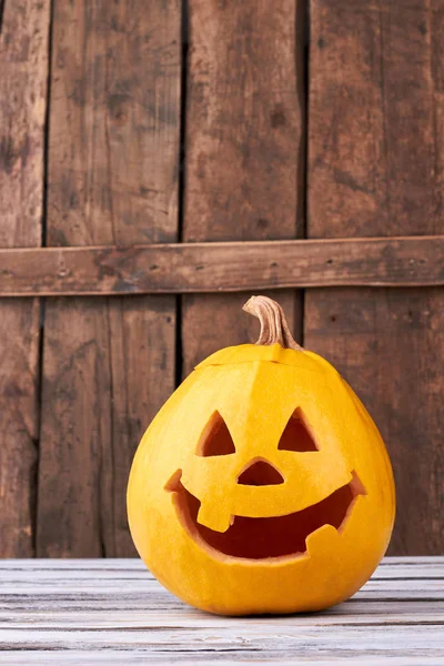 Funny Halloween pumpkin on wood background.