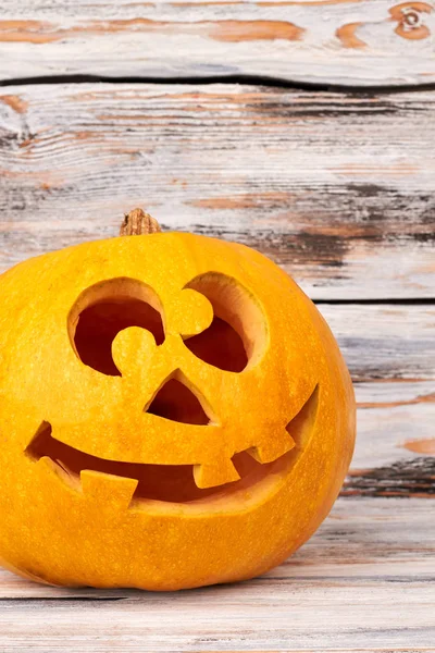 Funny Halloween pumpkin on wooden background.