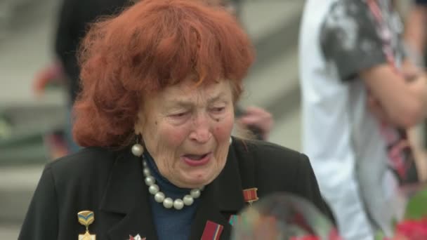 Alte Seniorin weint in Gedenken an tote Opfer des Weltkriegs. — Stockvideo