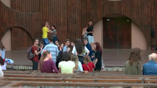 Jóvenes pasando el rato en el escenario del parque al aire libre . — Vídeo de stock