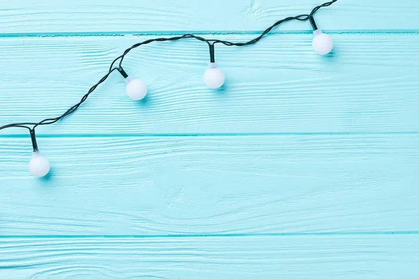 Luci di Natale su sfondo blu in legno. — Foto Stock
