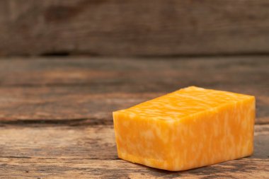 Ahşap arka plan üzerinde mermer peynir parçası.