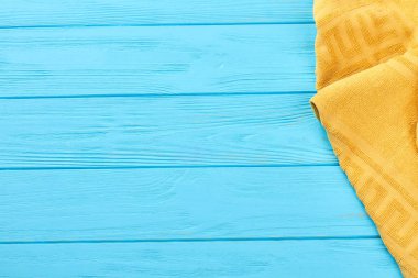 Mavi ahşap zemin üzerine sarı Havlu.
