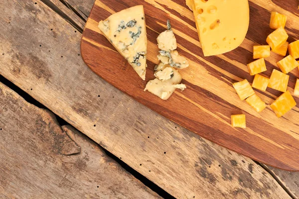 Various types of cheese on cutting board. — Stock Photo, Image