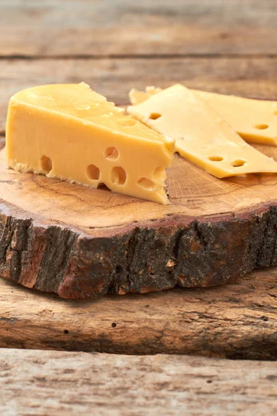 Slice of wood with Swiss cheese. — Stock Photo, Image