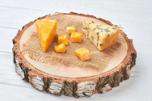 Cheese on round natural board.