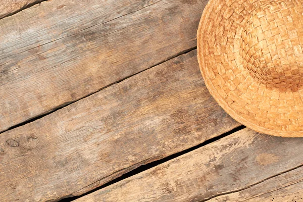 Vintage style straw hat on wooden background.