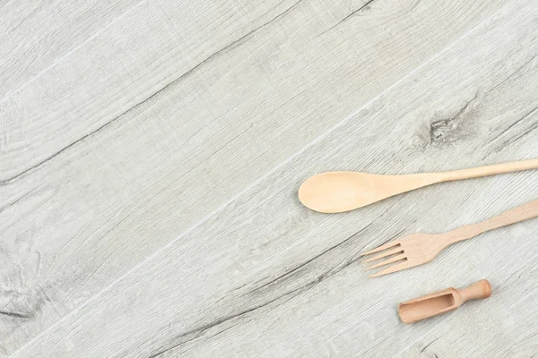 Kitchen wooden utensils on gray wooden background. — Stock Photo, Image