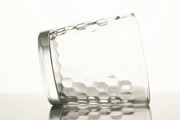 Leeres Glas auf reflektierender Oberfläche liegend. — Stockfoto