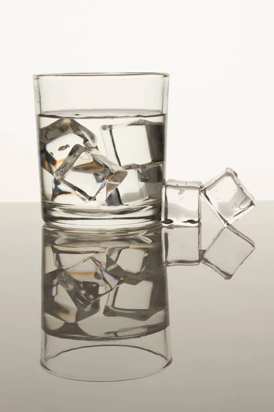 Copa de vidrio transparente con cubitos de hielo . — Foto de Stock