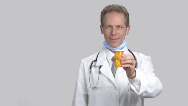 Mature handsome man recommending can of pills. — Stock Video
