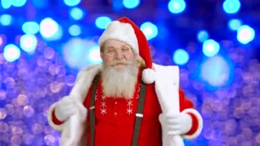 Neşeli Noel Baba mavi arka plan üzerinde dans ediyor.
