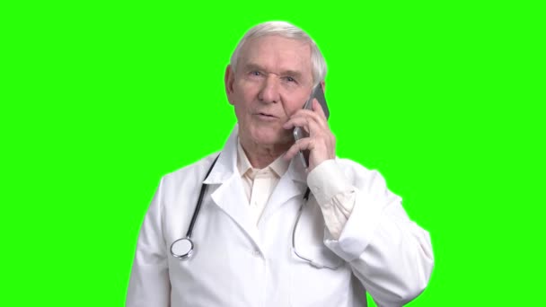 Old smiling doctor talking on the phone. — Stock Video
