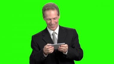 Smartphone üzerinde oyun oynamak eğlenceli neşeli iş adamı.