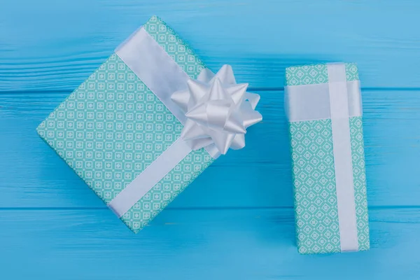 Two green boxes wrapped in patterned green paper.