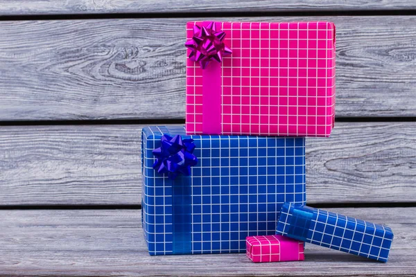 Scatole regalo colorate avvolte su sfondo di legno . — Foto Stock