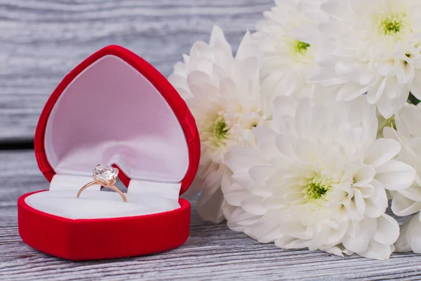 Red box with golden ring and white chrysanthemums.