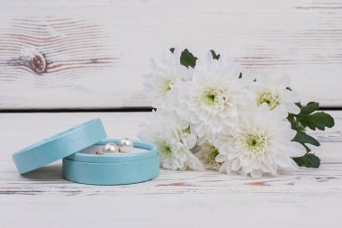 İnci küpe hediye kutusu ve çiçekler.