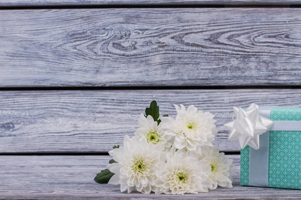 Caja de regalo y flores de crisantemo sobre fondo de madera . — Foto de Stock