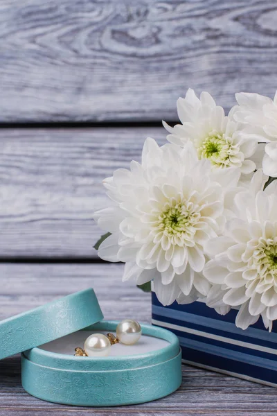Pendientes de perlas en caja de regalo y flores blancas . — Foto de Stock