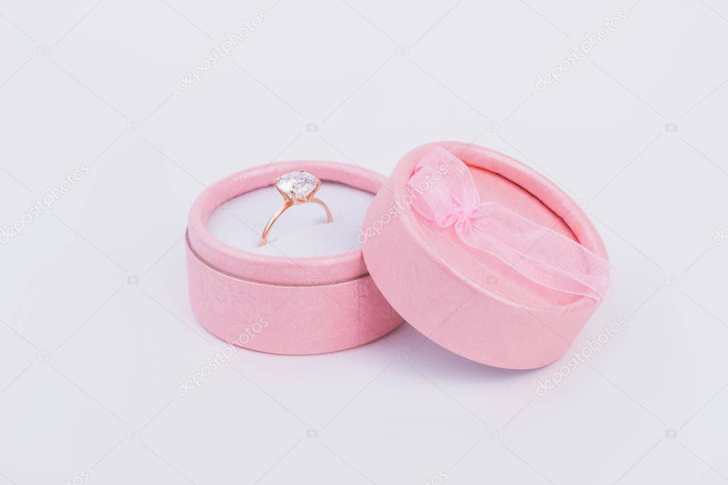 Golden ring with diamond in gift box. Pink gift box with engagement ring. Luxury gift for beloved woman.