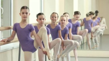 Küçük balerinler barre, germe egzersizleri yapıyor.