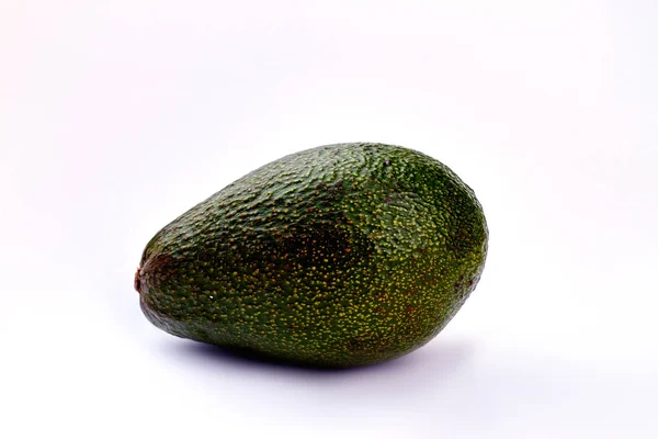 Ganze Avocado auf hellem Hintergrund. — Stockfoto