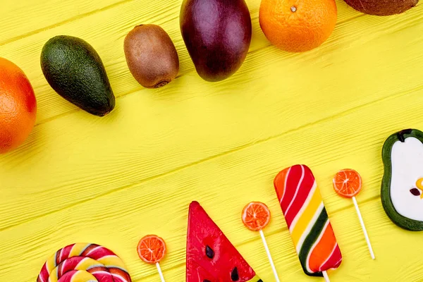 Vibrant fruits and candies on color background. — Stock Photo, Image