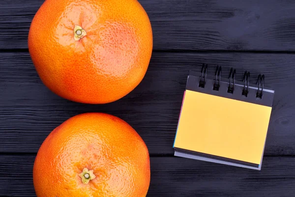 Dua buah jeruk dan notepad binder kecil . — Stok Foto