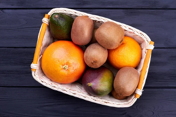 Assorted fruits in wicker basket, top view.