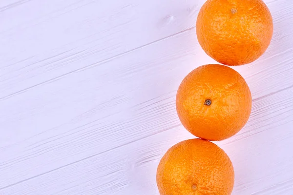 Fila de naranjas frescas sobre madera clara . — Foto de Stock